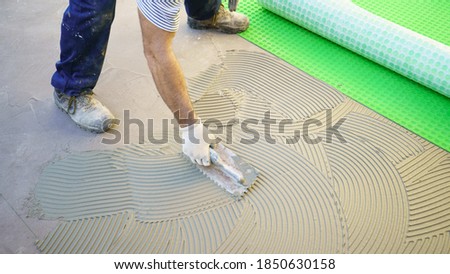 worker applying tile adhesive glue on the floor
 Royalty-Free Stock Photo #1850630158