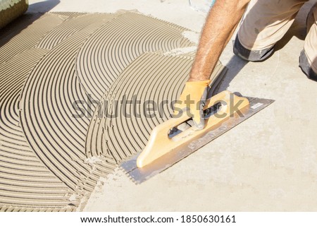 worker applying tile adhesive glue on the floor
 Royalty-Free Stock Photo #1850630161