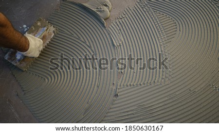 worker applying tile adhesive glue on the floor
 Royalty-Free Stock Photo #1850630167
