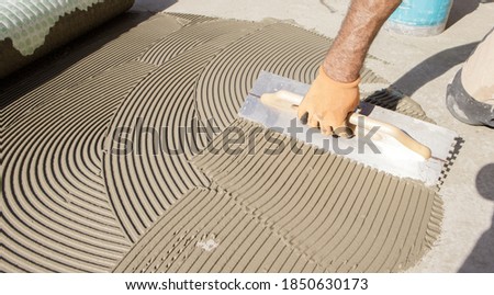 worker applying tile adhesive glue on the floor
 Royalty-Free Stock Photo #1850630173
