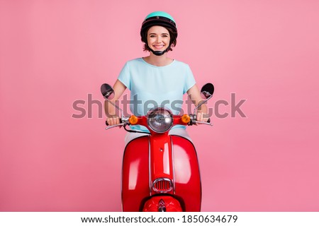 Photo of positive pretty girl ride moped enjoy road wear blue t-shirt slam isolated on pastel pink background