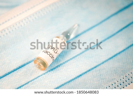 Glass ampoule with vaccine COVID-19, Vaccination against coronavirus helps strengthen immunity. Selective focus
