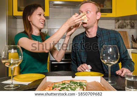 Family spending nice time together at home, looks happy and excited. Couple having fun, eating pizza. Togetherness, home comfort, love concept.