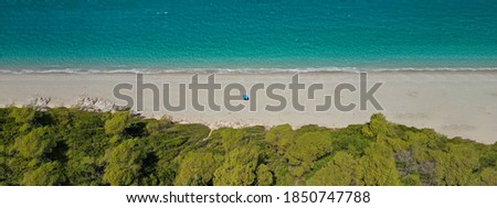 Aerial drone panoramic ultra wide photo of paradise exotic turquoise sandy bay covered in limestone and pine trees in Mediterranean popular destination