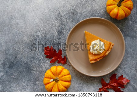 Traditional thanksgiving food on wooden table. Orange delicious homemade pumpkin pie with crust and decorative items. Thanksgiving table setting concept.Top view, close up, copy space, background.