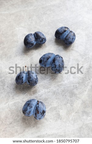 ugly organic blue double plums heart-shaped on a grey background