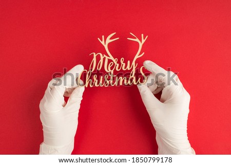 Best wishes on Christmas Day concept. Pov top above first person overhead close up view photo of hands in surgical gloves holding showing text with inscription isolated red background