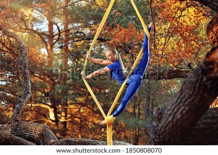 Picture of an flying gymnast making splits on aerial silks