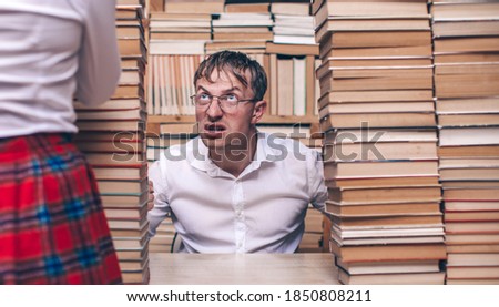 Beautiful young couple sitting in librar. Emotion face. Funny photo. Couple. Book. 