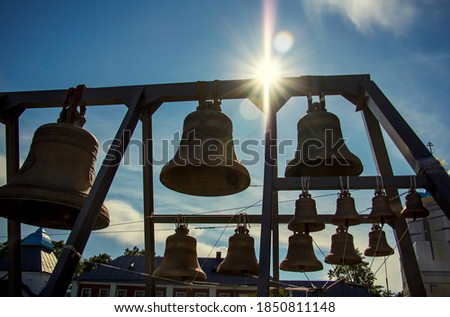 Church bells of different sizes against the blue sunny sky