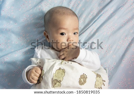 Adorable 4 month old Chinese baby sucking his own finger