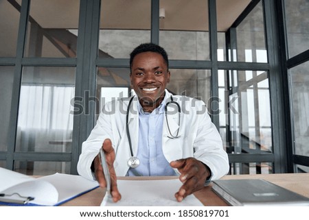 Happy african male doctor talking to camera during telehealth mobile consultation. Black physician consulting patient in virtual telemedicine phone app chat. Tele medicine videocall visit, headshot. Royalty-Free Stock Photo #1850819701