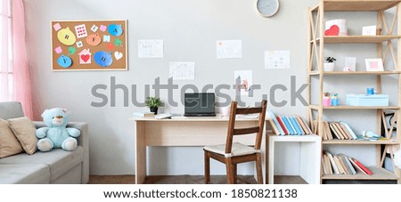 School child room interior space with table, couch, bookcase, books and laptop on table indoors at home apartment background. Children homeschool, online distance remote virtual learning, banner. Royalty-Free Stock Photo #1850821138