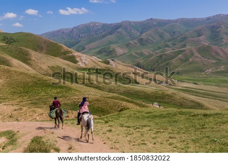 Horse riders in mountains near Song Kul lake, Kyrgyzstan