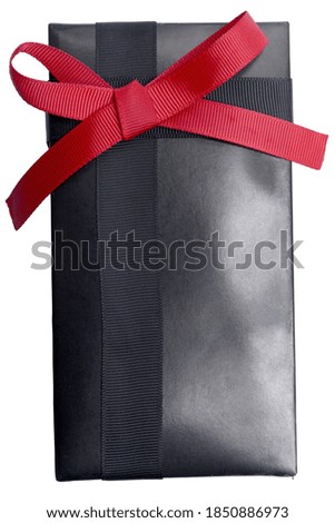 Black gift box with red ribbon isolated over white background
