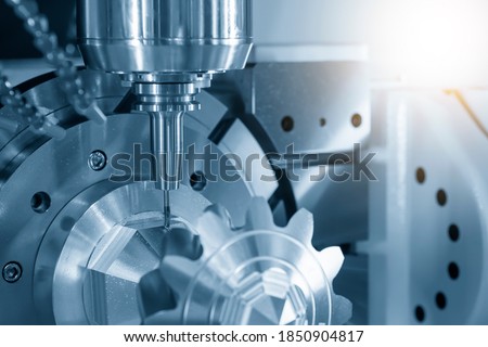 The hi-precision 5-axis machining center cutting the metal gear parts. Hi-technology  parts manufacturing process by multi-axis CNC milling machine. Royalty-Free Stock Photo #1850904817