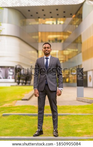 Full length shot of African businessman standing outdoors