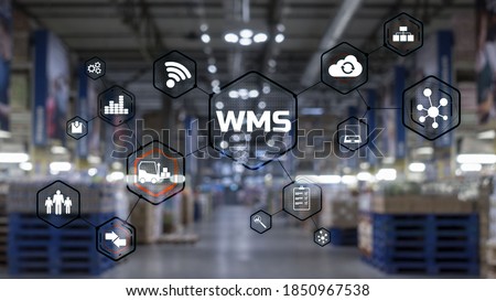 Inscription WMS on blurred warehouse background. Werehouse Management System. Royalty-Free Stock Photo #1850967538