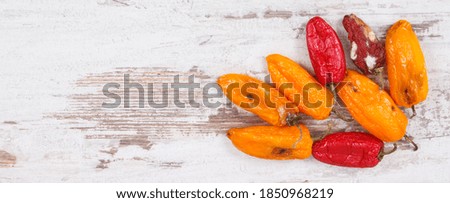 Old wrinkled moldy peppers on old rustic board, concept of unhealthy and disgusting vegetable. Place fo text Royalty-Free Stock Photo #1850968219