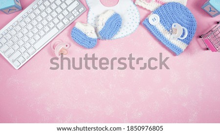 Baby nursery clothing mom bloggers desktop workspace with pink and blue accessories on stylish pink textured background. Top view blog hero header creative composition flat lay. Negative copy space.