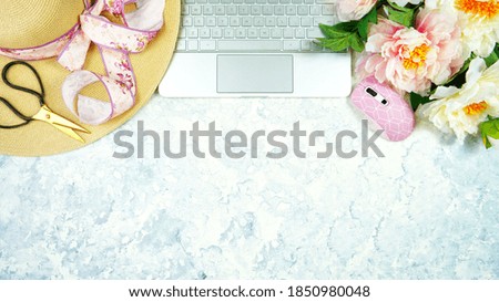Spring theme, peonies and sunhat desktop workspace with laptop on stylish white marble textured background. Top view blog hero header creative composition flat lay.