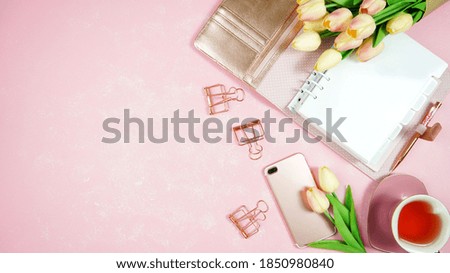 Feminine pink theme desktop workspace with personal planner on stylish textured background. Top view blog hero header creative composition flat lay.