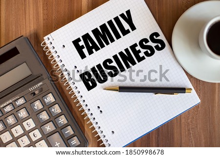 FAMILY BUSINESS written in a white notepad near a calculator and a cup of coffee on a dark wooden background