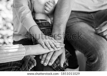 Concept of unity, support, protection, happiness. Child hand closeup into parents. Hands of father, mother, keep hand little baby. Parents hold the baby hands.