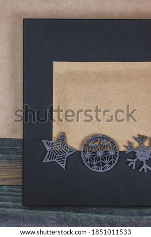 Postcard for christmas congratulation with craft postcard on black background with grey christmas toys