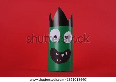 Funny green monster on red background. Halloween decoration