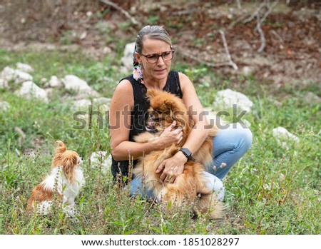 young pomeranians and woman  picture in the nature, in autumn