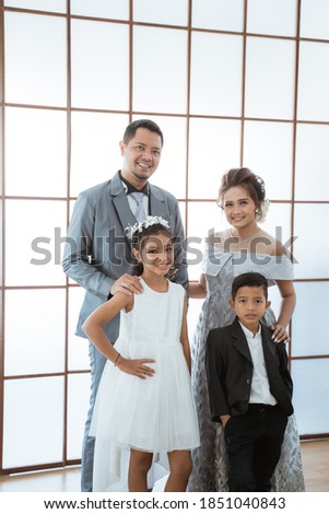 Portrait of a happy family with modern clothes. Family photo concept standing by the window