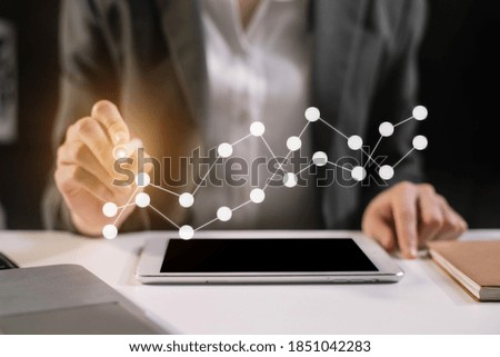 Businessman using tablet and stock market charts at office in the morning. 