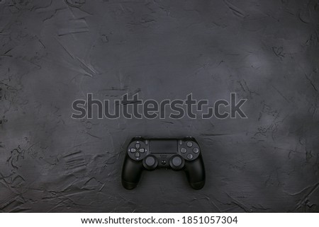 Black joystick gaming controller on black background. Top view with copy space.