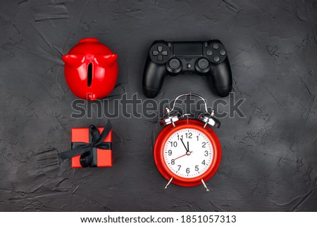 Set of piggy bank, joystick, gift and alarm clock on black background. Holiday sale or black friday concept. Top down composition