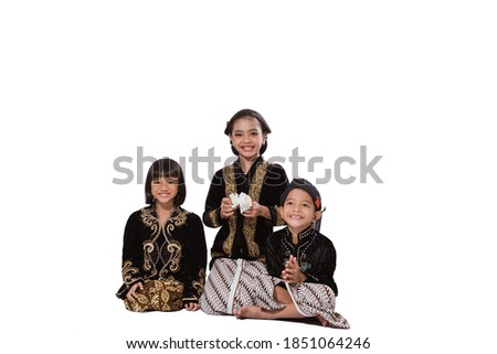 Happy portrait of three adorable brothers and sisters. In Javanese outfit concept in the studio photo