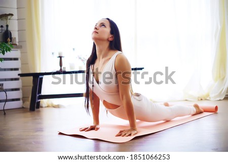 Beautiful athletic girl doing yoga exercises enjoy meditation at home. No stress, healthy habit, anxiety relief concept. Lotus.