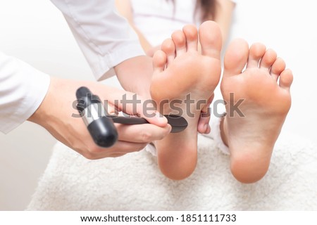 A neurologist doctor checks the plantar reflex in a patient s girl with a neurological hammer. Diagnosis of multiple sclerosis diseases, cerebrovascular accident Royalty-Free Stock Photo #1851111733