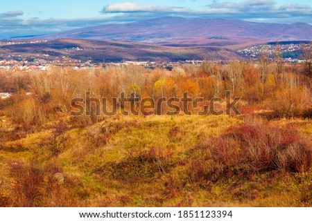 rural valley in the morning. beautiful autumn scenery in mountains. town in the distant valley. clouds on the blue forenoon sky