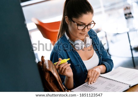 Portrait of a pretty young woman studying while sitting at the table