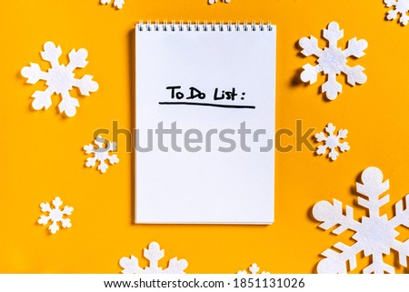 Christmas sheet of paper with the inscription "to do list" on a yellow background with snowflakes