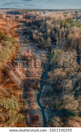 Aerial view of small forest river Skalba in Moscow region, Russia. Beautiful autumn landscape at sunny november day