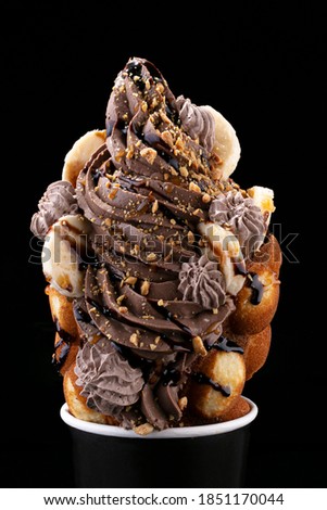Yummy dessert isolated on black background. Chocolate Ice cream, fresh baked wafer and delicious caramel syrup