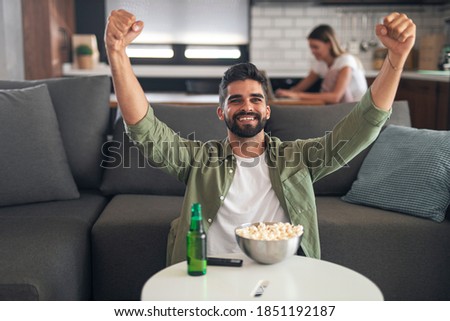 Overjoyed man watching sports on television. He is happy because his team just scored a goal