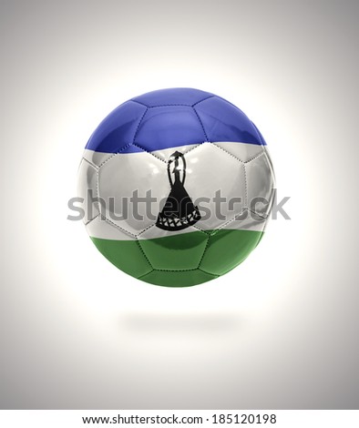 Football ball with the national flag of Lesotho on a gray background