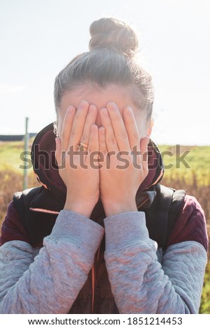 
photo showing the girl's face covered with her hands