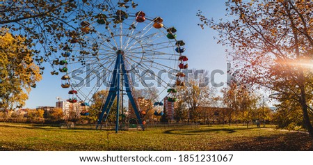 A front view of an old colorful Ferris wheel in a town park