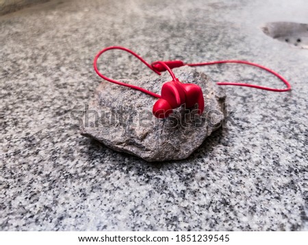 Picture of red color wireless earphone or ear buds