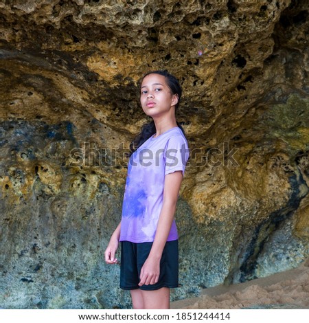 Portraits an Asian young girl, posing standing under the amazing coral reef wall. Casual theme concept.