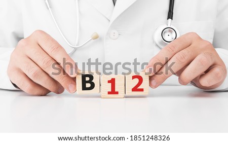 Doctor holds wooden cubes in his hands with text B12 Royalty-Free Stock Photo #1851248326